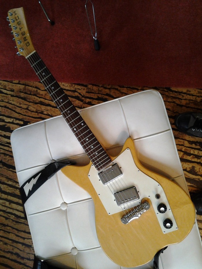 The card stock shim keeps the neck pickup tilted the right way.